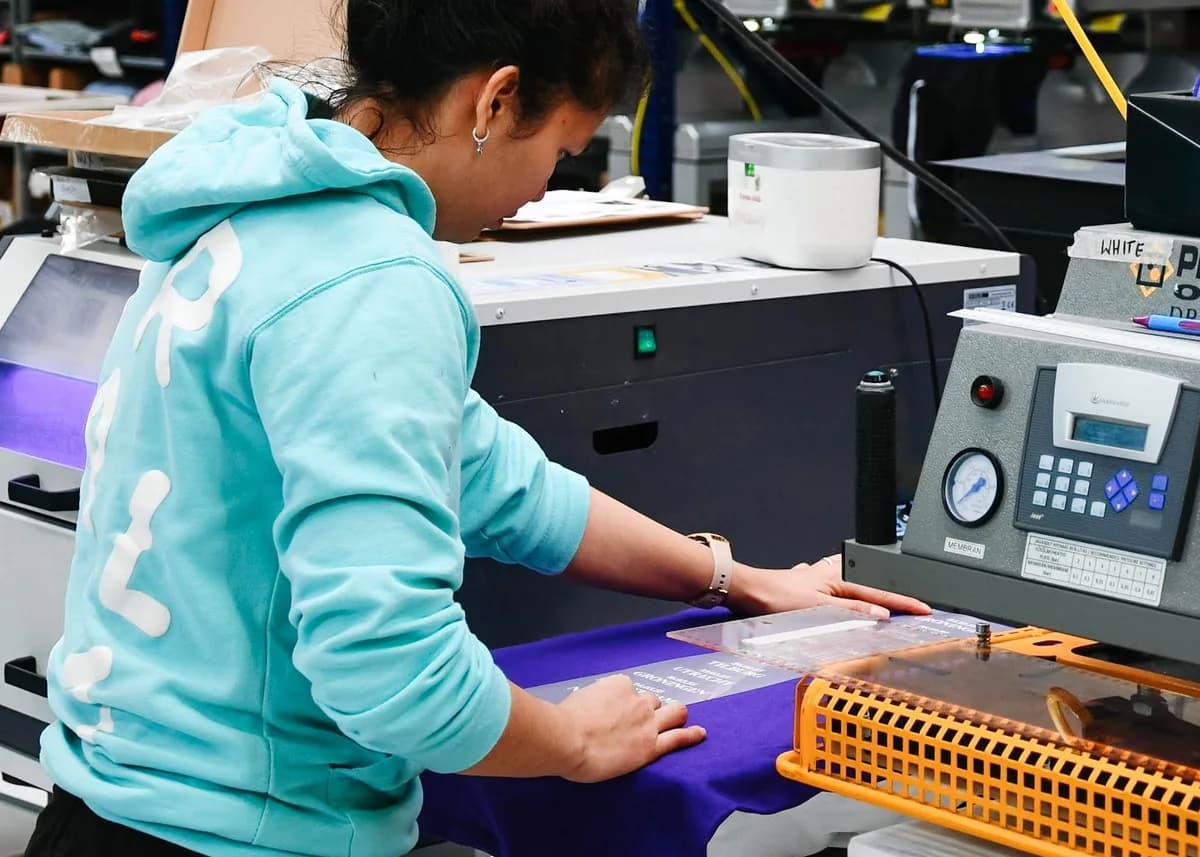 A Droplet team member folding a freshly printed t-shirt in the print studio