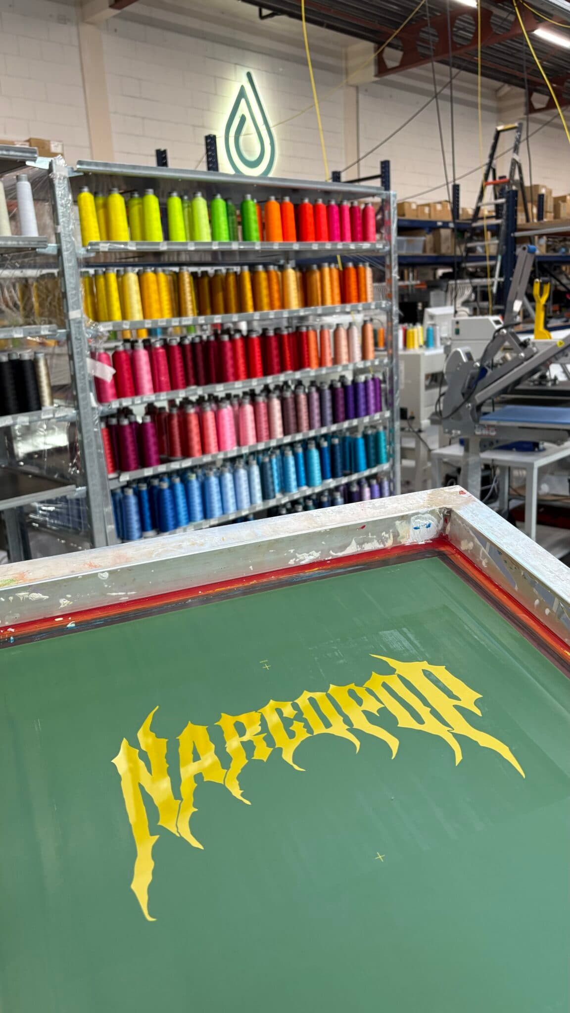A screen printing frame in front of the thread wall