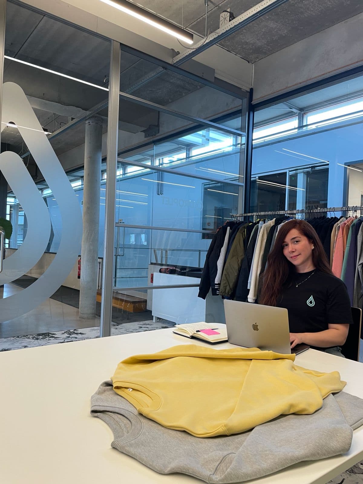 A DROPLET designer at work in the studio, with sample garments on the rail